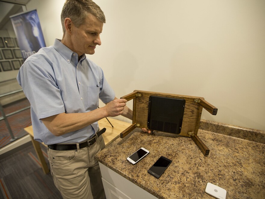 Morris Kesler, chief technology officer at WiTricity, shows how a wireless charging pad can be installed on a table.