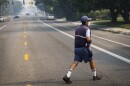 A postal worker crosses a street  as smoke from Oregon wildfires affects air quality in downtown Boise. He is wearing a N-95 mask. 