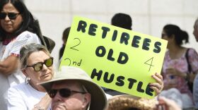 Yvonne Landin, a retired teacher from Corpus Christi, holds a sign as retired teachers gather at the Teacher Retirement building in Austin on Thursday.