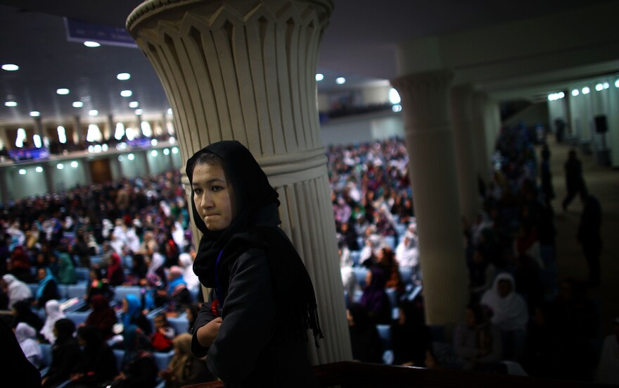 An Afghan woman listens to presidential candidate Ashraf Ghani during a campaign rally in Kabul on March 9, International Women's Day. Women will play a greater role in choosing Afghanistan's next president than ever before.