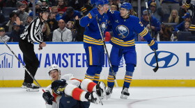 Buffalo Sabres defenseman Rasmus Dahlin, center, celebrates with right wing Jack Quinn, right, after scoring as Florida Panthers center Lars Eller (20) lays on the ice during the first period of an NHL hockey game Monday, Oct. 12, 2026, in Buffalo, N.Y.