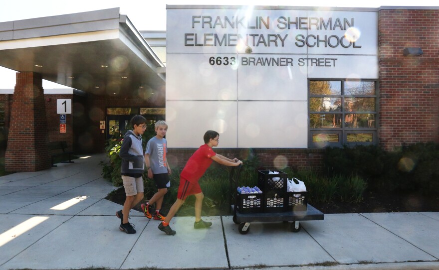 Franklin Sherman Elementary students Nicola Hopper, 11, Jake Hensley, 11, and Aya Hopper, 10, transport collected food from their school to McLean Baptist Church, located across the street from the school.