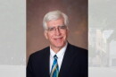 A man in a suit, tie and glasses