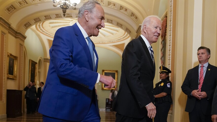President Biden walks with Senate Majority Leader Chuck Schumer, D-N.Y., at the Capitol on Wednesday as he arrives to discuss the latest progress on his infrastructure agenda.