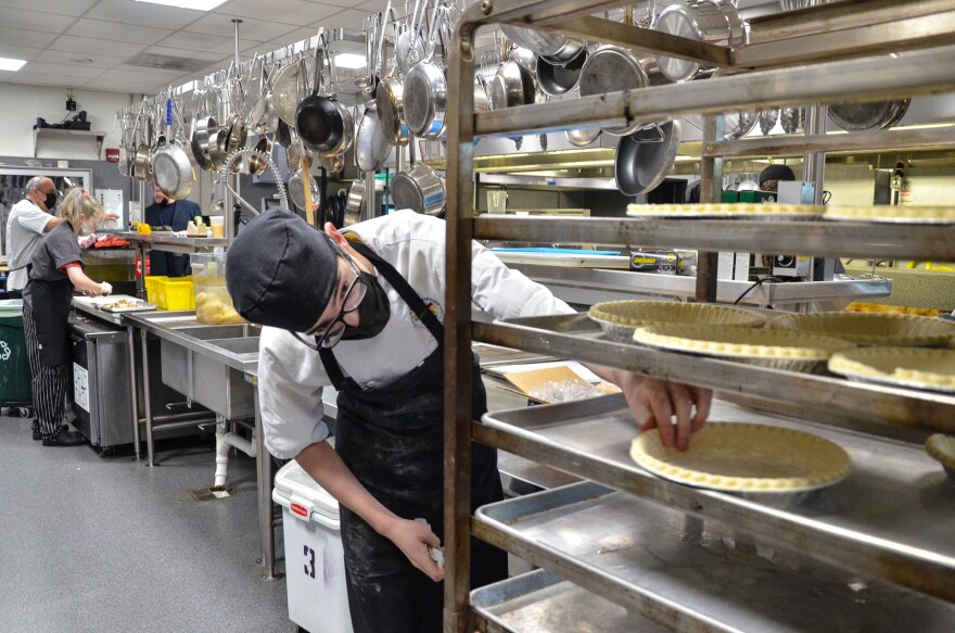 Keegan Bachert, 15, a sophomore in Shawnee Mission Culinary Arts and Hospitality Signature Program, sets out pie crusts that will be filled with chicken pot pie ingredients as students there prepared 250 meals for families in the district.