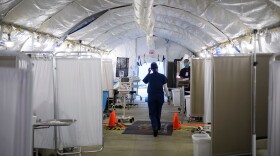 A nurse wears PPE as she attends to patients in a suspected COVID-19 patient triage area set up in a field hospital tent outside of Martin Luther King Jr. Community Hospital on Jan. 6, 2021 in Los Angeles, California. (Patrick T. Fallon/AFP/Getty Images)
