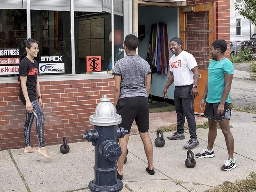 Justice Williams with gym goers and kettlebells at CORE in Brookline, Mass. [Robin Lubbock / WBUR]