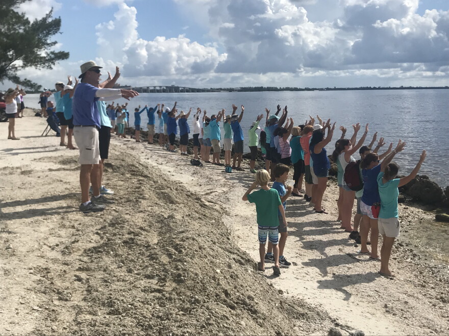 About a hundred people lined the beach along Sanibel Causeway for "Hands Along the Water."