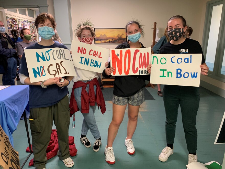 Teen climate activists hold their signs opposing the Merrimack Generating Station, a coal burning plant in Bow.