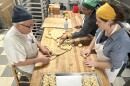 Tom Quinn (left), Anna Hanau (front right) and Jenny SoLis prep challah on Jan. 28, 2026, at Malek's Bakery in Brighton.