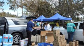 Volunteers, wearing the green vests, assist those who come to the center seeking food, water and supplies. A representative from Chick-fil-A unpacks hot sandwiches donated by the restaurant chain. (Melissa Feito/FPREN)