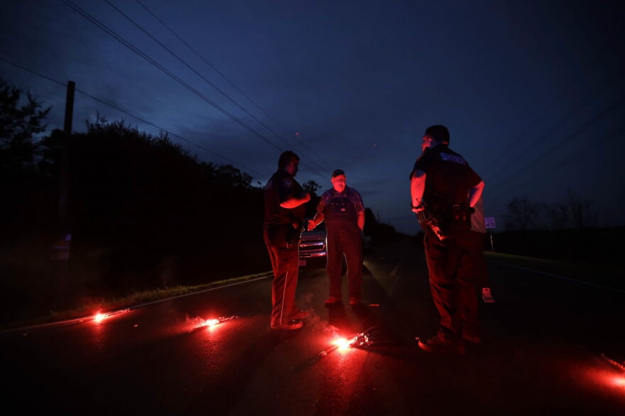 A man talks with officers at a roadblock less than three miles from the Arkema Inc. chemical plant Thursday, Aug. 31, 2017, in Crosby, Texas. The Houston-area chemical plant that lost power after Harvey engulfed the area in extensive floods was rocked by multiple explosions early Thursday, the plant's operator said. (Gregory Bull/AP)