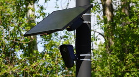 A Flock camera attached to a pole.