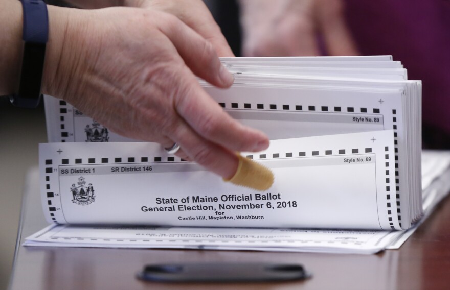 In this Nov. 12, 2018 file photo, ballots are prepared to be tabulated for Maine's Second Congressional District's House election in Augusta.