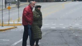 Pedestrians cross a street during a cold day in Chicago, Sunday, Nov. 9, 2025. (AP Photo/Nam Y. Huh)