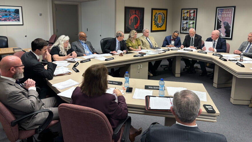 State lawmakers sit around a U-shaped table.