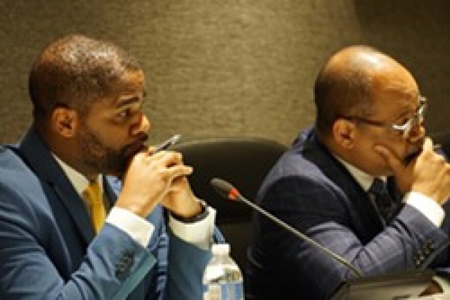 Superintendent Terry Dade and school board President Van White listen to speakers during a board meeting.