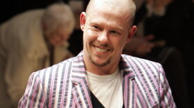 British fashion designer Alexander McQueen acknowledges applause after a March 2006 show in Paris.