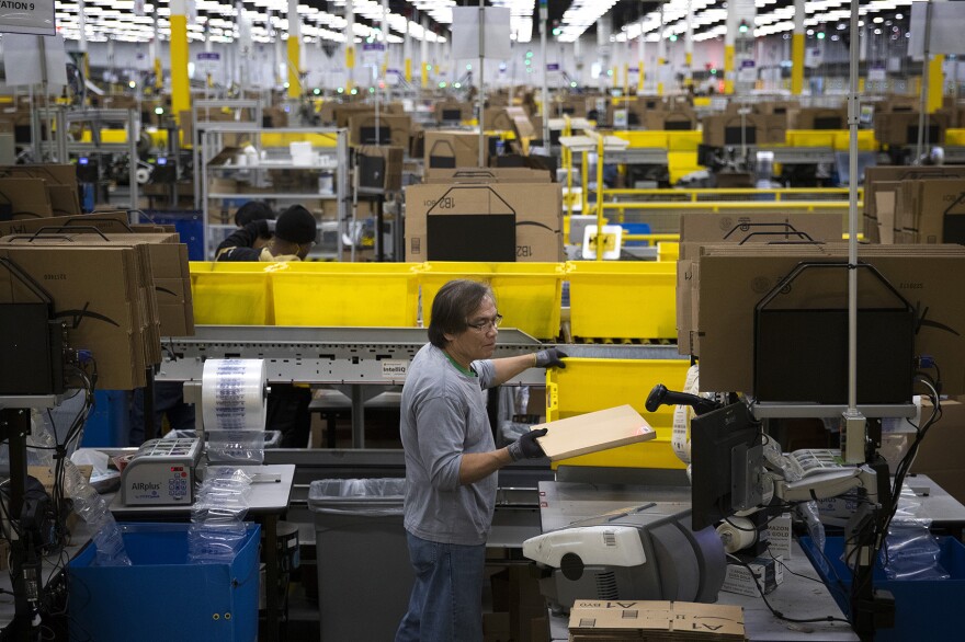 Amazon employee Filomeno Saya packages items at an Amazon fulfillment center on Friday, November 3, 2017, in Kent.