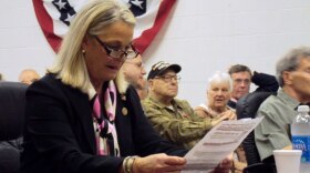 Rep. Ann Marie Buerkle (R-Onondaga Hill) reads an attack flyer before being introduced at a town hall event Friday.