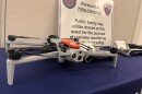 A grey drone sits on a blue table