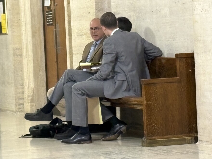 Paul Florsheim (facing camera) confers with his legal team.