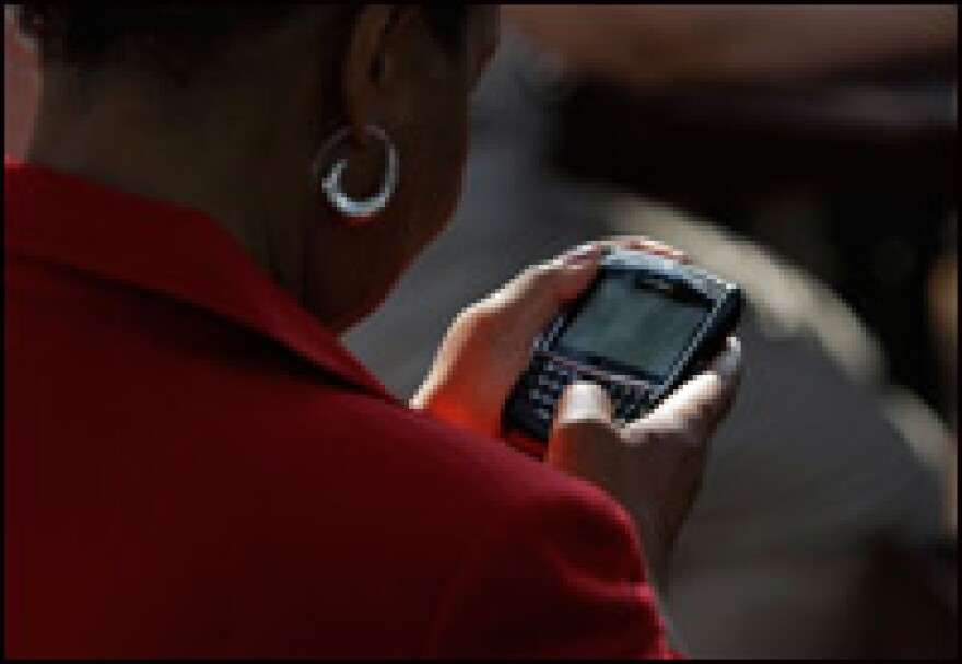 A woman works on her BlackBerry phone on Aug. 21, 2008, in Chester, Va., after she received instructions explaining how to get a text message from the Obama campaign announcing the identity of his running mate.