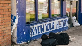 A homeless man charges his phone outside the Civic Media Center, located at 433 S. Main Street, June 15, 2021. (Houston Harwood/WUFT News)