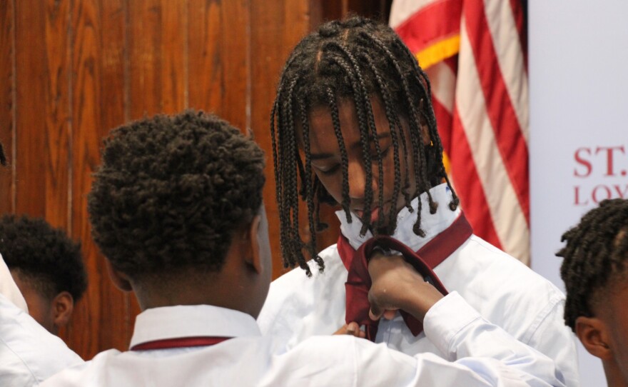 An 8th grade student assists a 6th grade student to tie his first official school tie at the Academy's Sixth Grade Tie Ceremony. Photo: Jennifer A. Summers