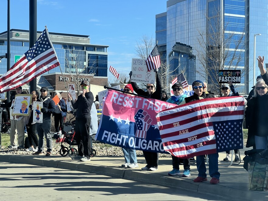 Residents along Metcalf Avenue in Johnson County protest the Trump administration on Saturday during the third round of No Kings rallies.