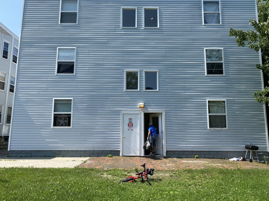 Pires carries a food delivery into an apartment building on Washington Ave in Portland. He said that once he secures a fulltime job, he probably won't be able to continue volunteering four days a month on the food assistance program.