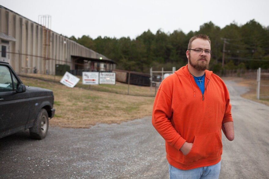 Josh Potter stands in front of the automotive parts plant where he was injured in a work-related incident in September 2013 in LaFayette, Ga.
