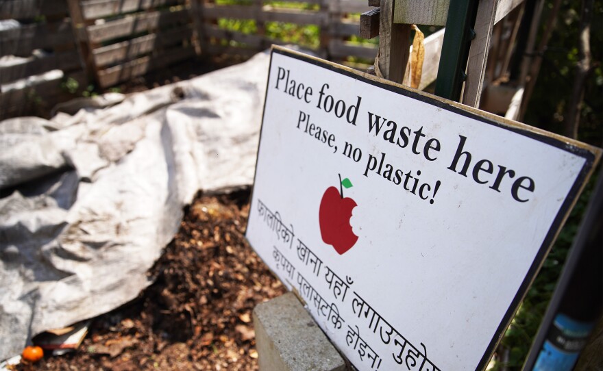 A sign at Akron Cooperative Farms indicates that a compost pile should have food waste — and not plastic — added to it.