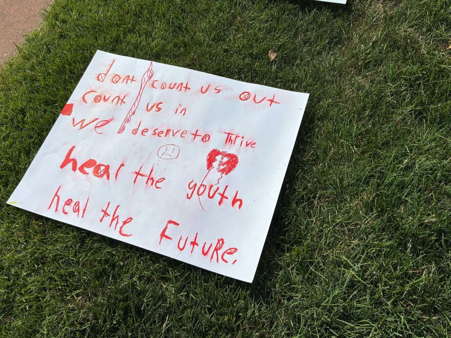 A sign made by a child that says "Don't count us out, count us in, we deserve to thrive. Heal the youth, heal the future."