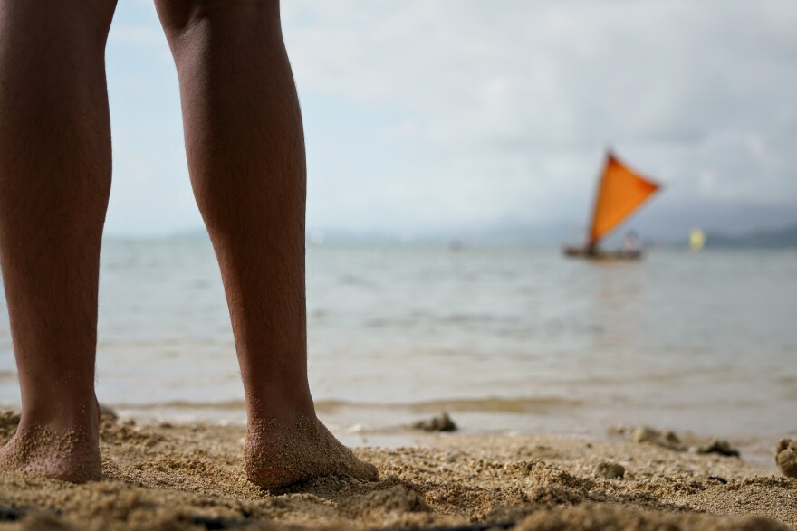 A volunteer stands on the shore awaiting the waʻa to help arriving FestPAC delegates on June 5, 2024.