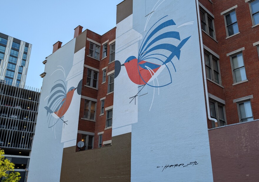 A mural of two bluebirds painted on the side of a building.