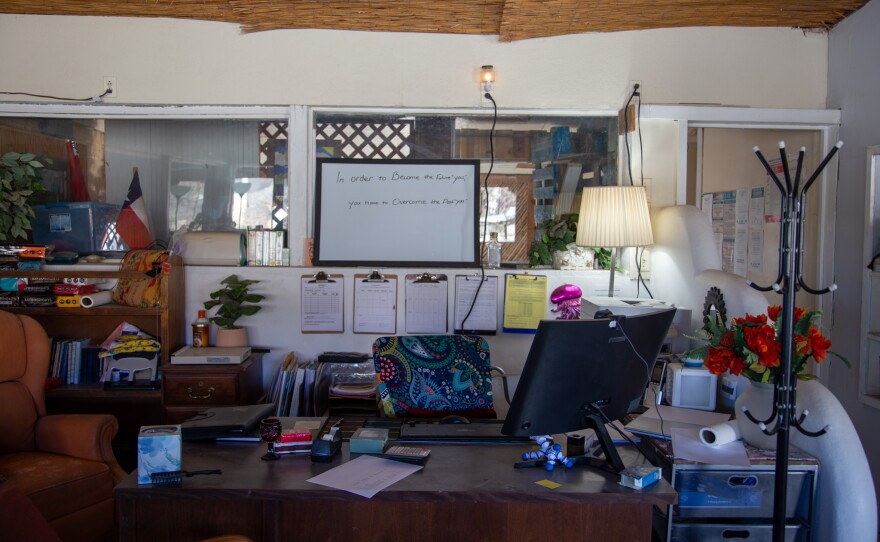 A white board above a client advocate’s desk in Terlingua reads “in order to become the future you, you have to overcome the past you.”