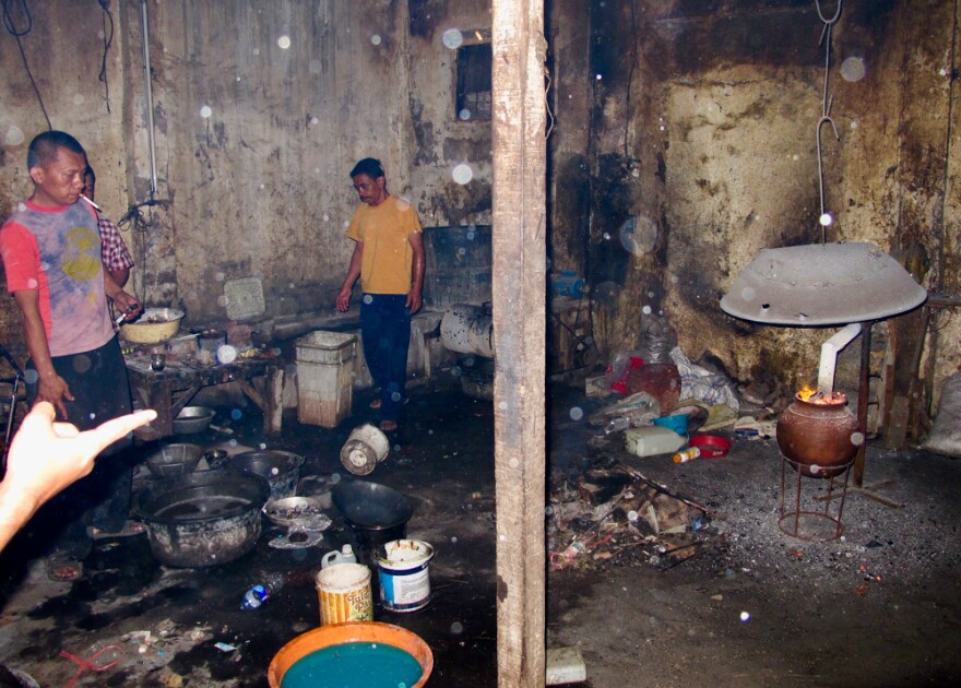 At a "backyard" recycling operation just outside of Jakarta, men place circuit boards in an oven and fire them to smelt out gold and other precious metals.