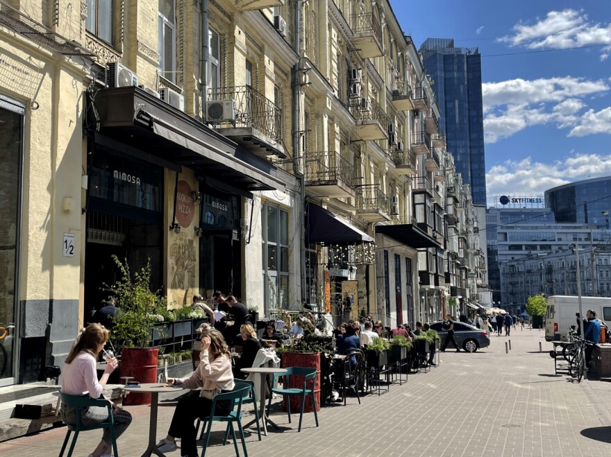 While some parts of the Ukrainian capital have been torn apart by the war, others are unscathed. In downtown Kyiv diners sit outside a pizza restaurant at lunch time.