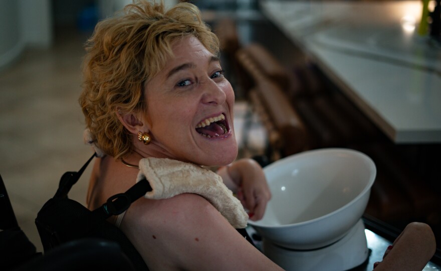Woman with blonde hair looks at camera while holding white bowl