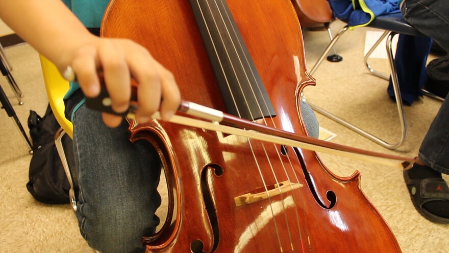 A student plays a cello during class. 