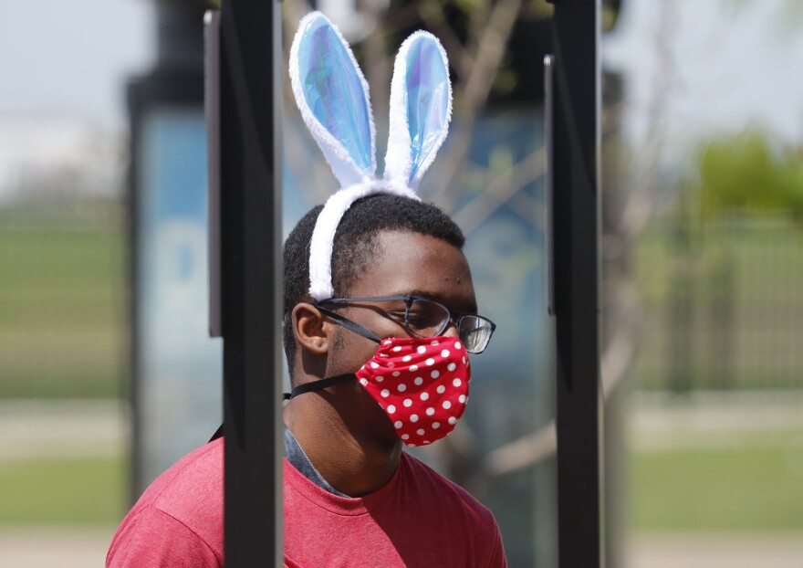 Amid COVID-19 concerns, a fast food worker wears a mask and Easter bunny ears as he works at a Chick-fil-A restaurant in Dallas on Tuesday.