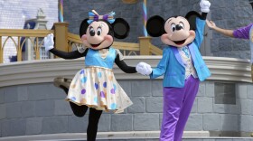 Minnie and Mickey Mouse perform for guests during a musical show in the Magic Kingdom at Walt Disney World Friday, July 14, 2023, in Lake Buena Vista, Fla. Disney on Tuesday, Nov. 14, released a study showing its economic impact in Florida at more than $40 billion, as it battles in courts with Florida Gov. Ron DeSantis and his appointees over their takeover of the district that governs the entertainment company's massive resort in central Florida.(AP Photo/John Raoux, File)