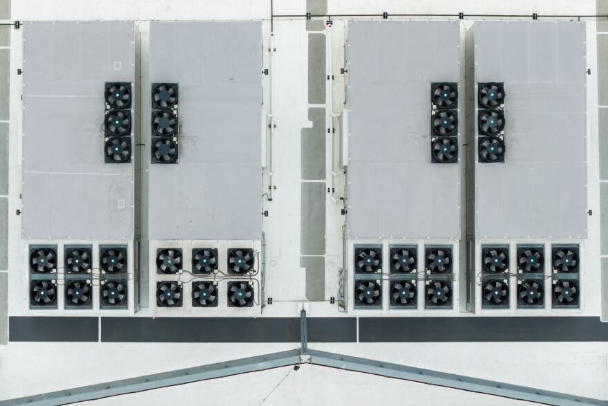An aerial image directly above the roof of a data center. The structure contains rows of fans. 