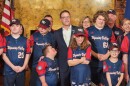 Gov. Josh Shapiro poses for a photo with members of the Wyoming Valley Challenger baseball team.