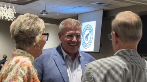 Man speaks to a pair of supporters 