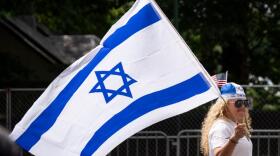 A woman holds an Israeli flag while walking down Fifth Avenue during the Israel Day Parade, Sunday, May 31, 2026, in New York. (Emil T. Lippe/AP)