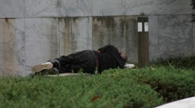 homeless man sleeping on grass