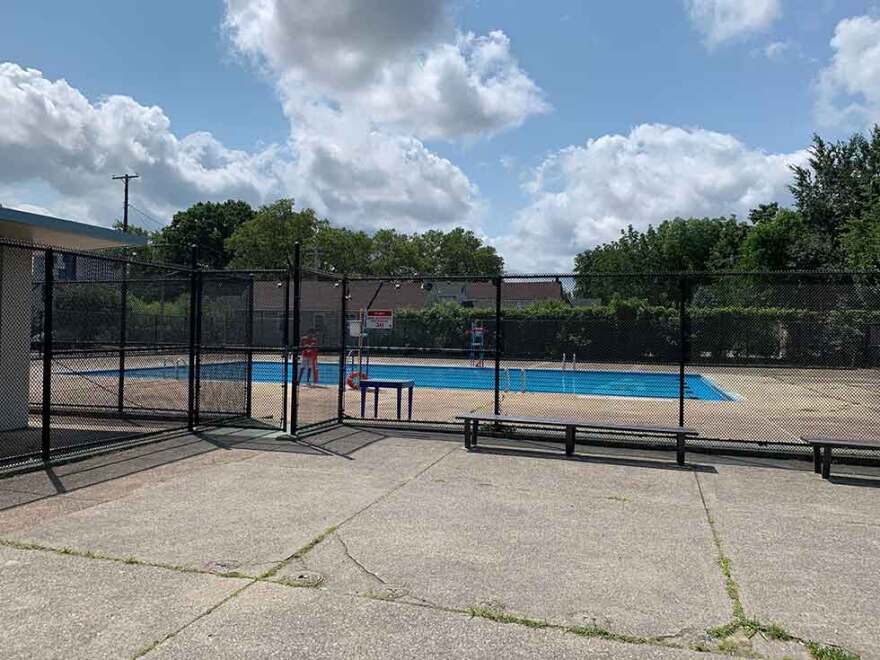 A public pool surrounded by concrete and a chain link fence in Cleveland's Clark-Fulton neighborhood.