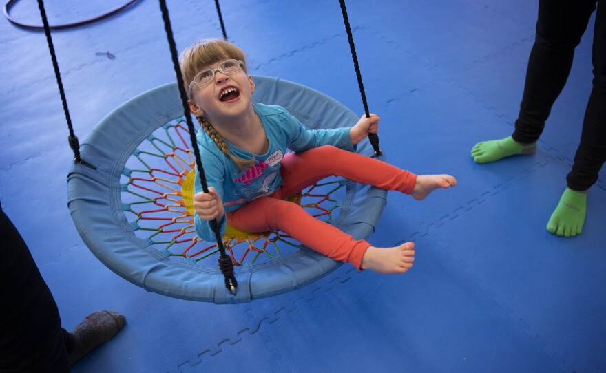 Lillian Rockett, 4, laughs as she is pushed on a circular swing on Sunday, October 1, 2017, at We Rock the Spectrum Kid's Gym in Bellevue.